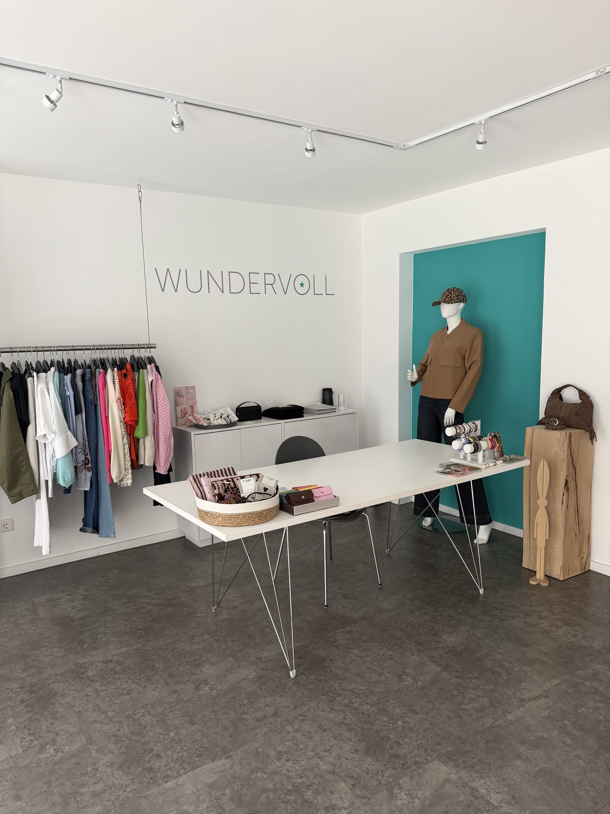 Ladenansicht mit türkiser Wand und Frühjahrskollektion